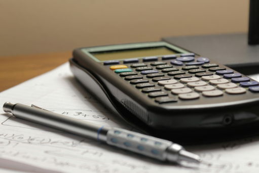 a-calculator-and-a-pen-sitting-on-top-of-a-piece-of-paper.jpg a calculator and a pen sitting on top of a piece of paper